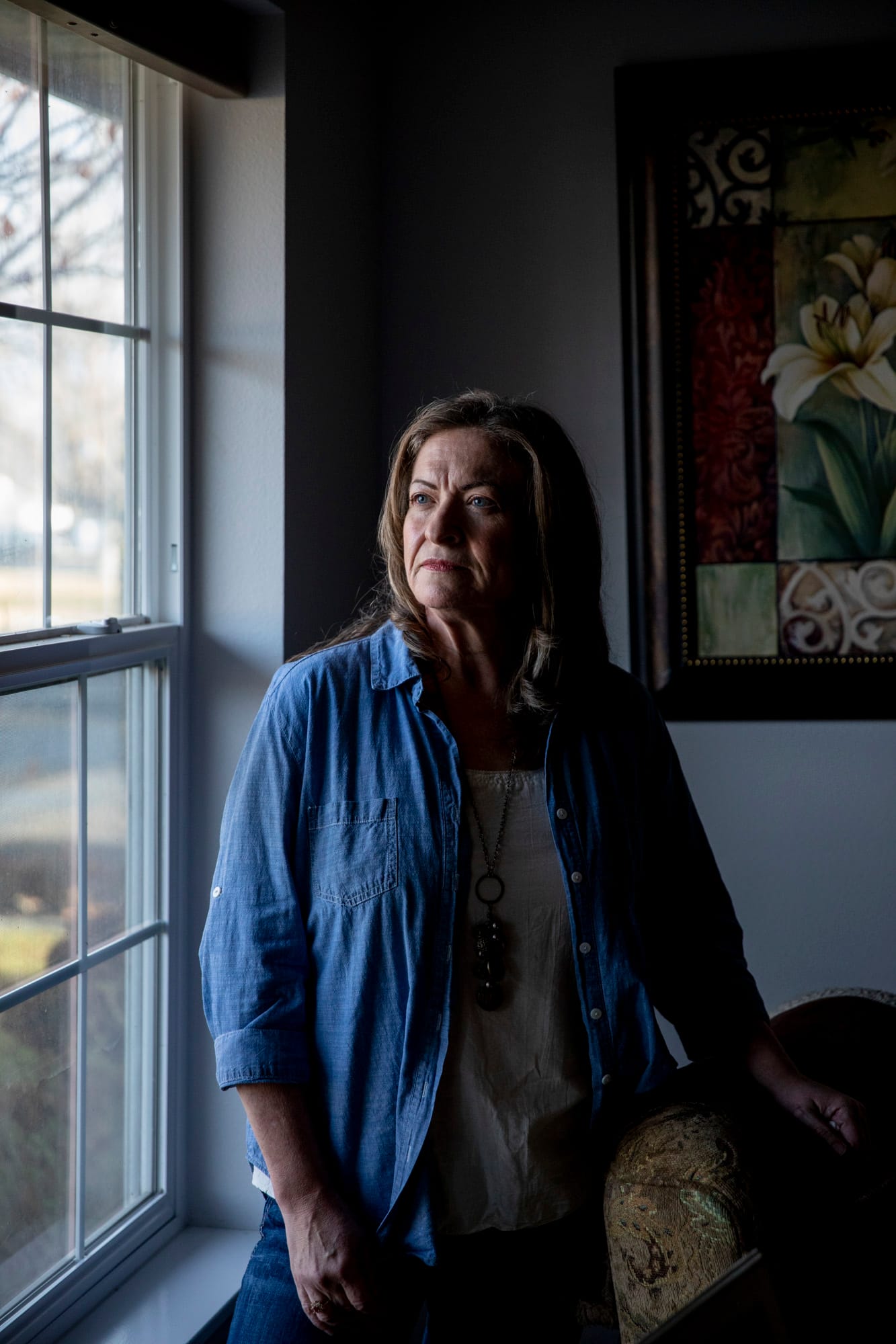 Penny Quist stands by a window inside her home