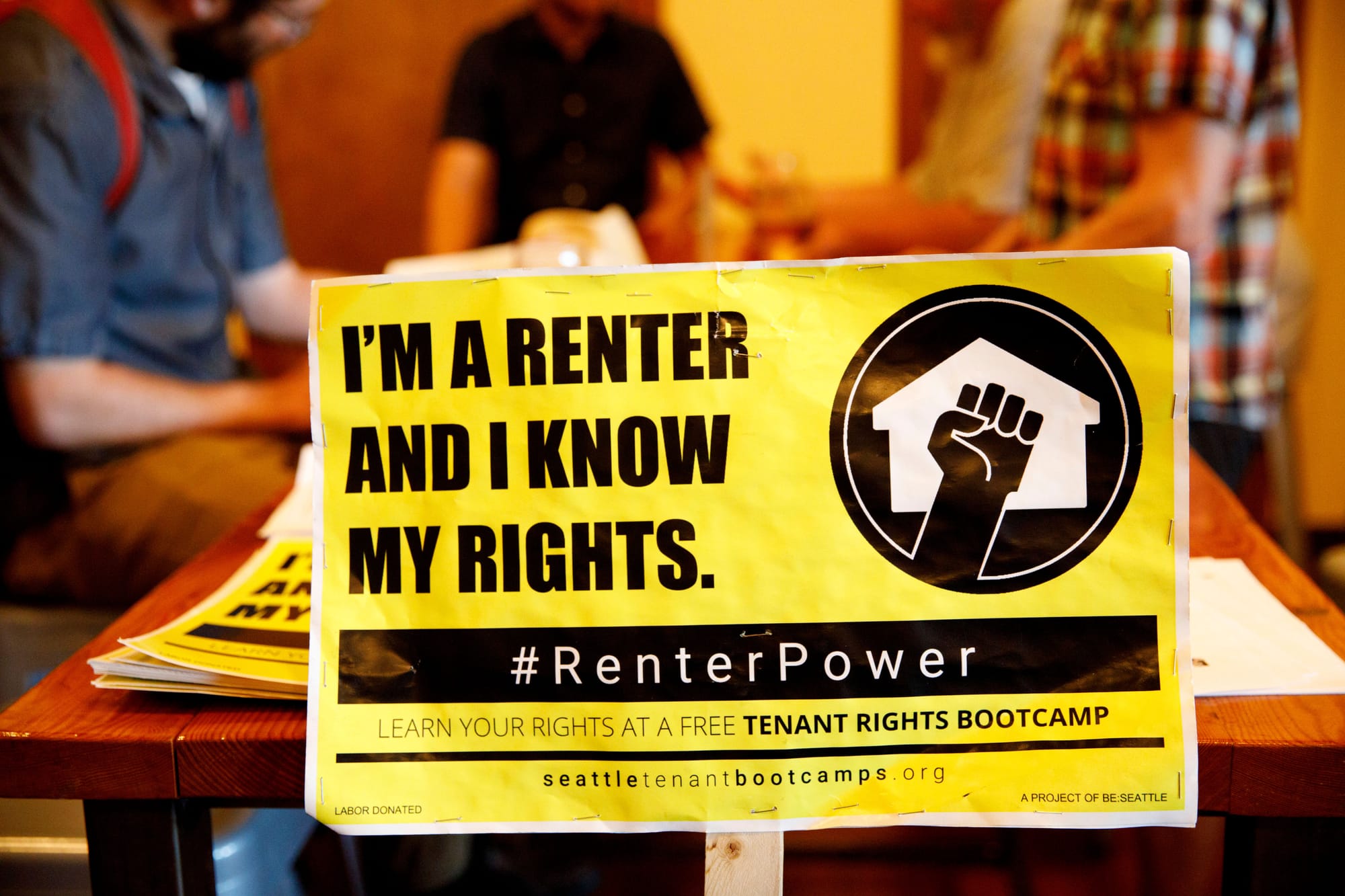 A sign rests on the table during a Tenant Rights Bootcamp on Wednesday, July 25, 2018 at Schilling Cider House in Fremont, Seattle, WA. The event was hosted by Be:Seattle and provided information on Seattle tenants rights. (Sarah Hoffman/Crosscut)