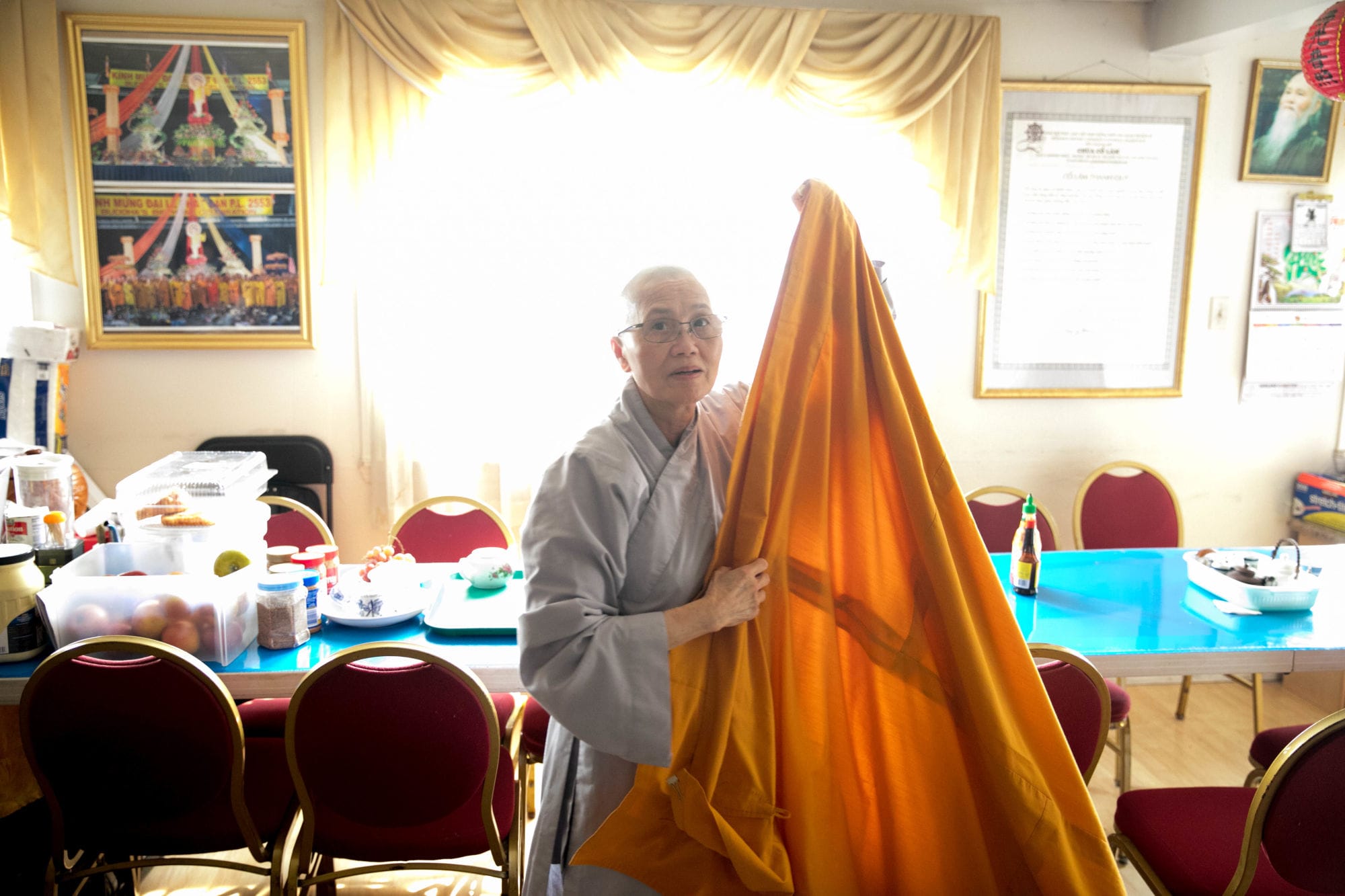 A Buddhist monk prepares her saffron robe