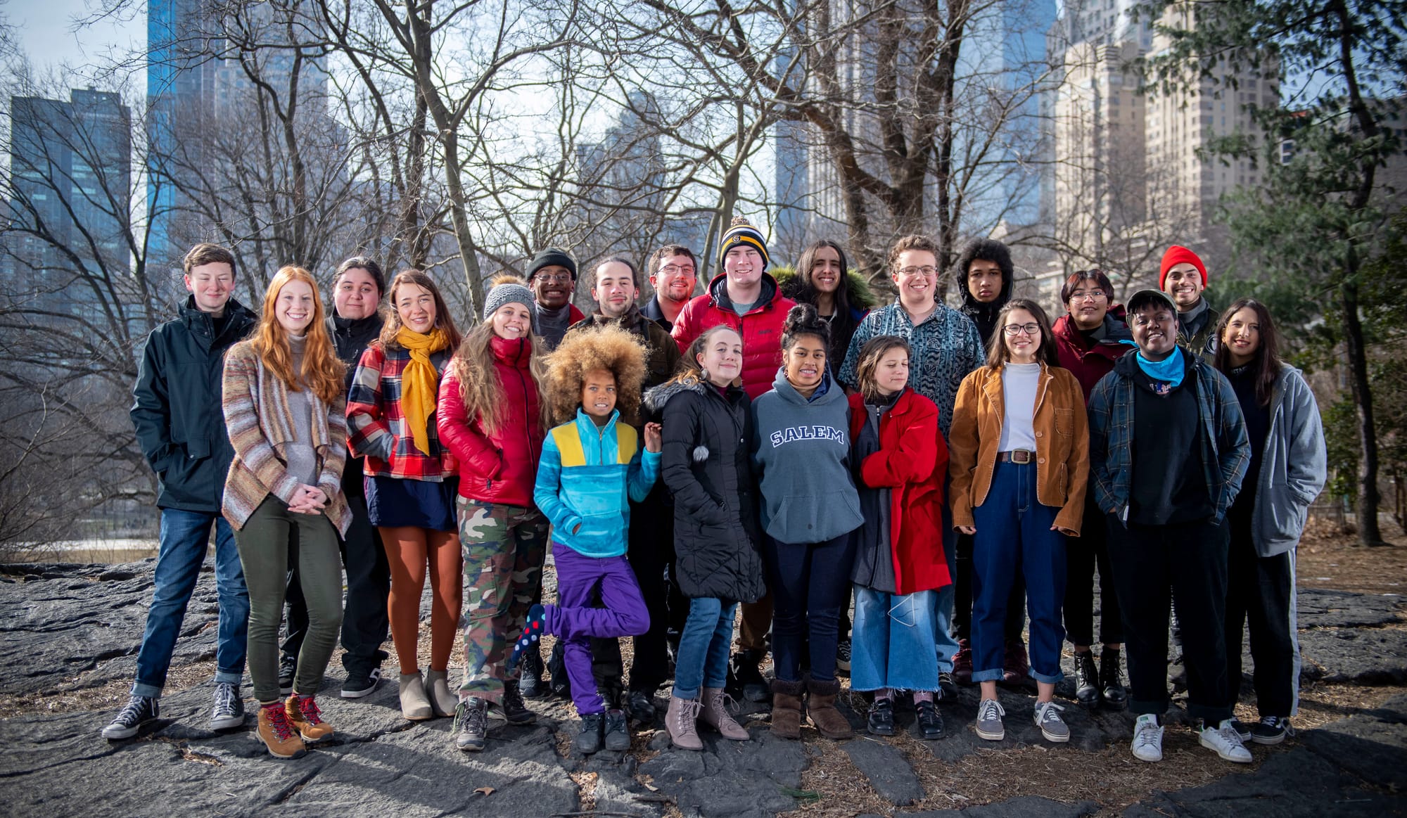 The youth plaintiffs take a photo in Central Park, standing in the park with the city as a backdrop. 