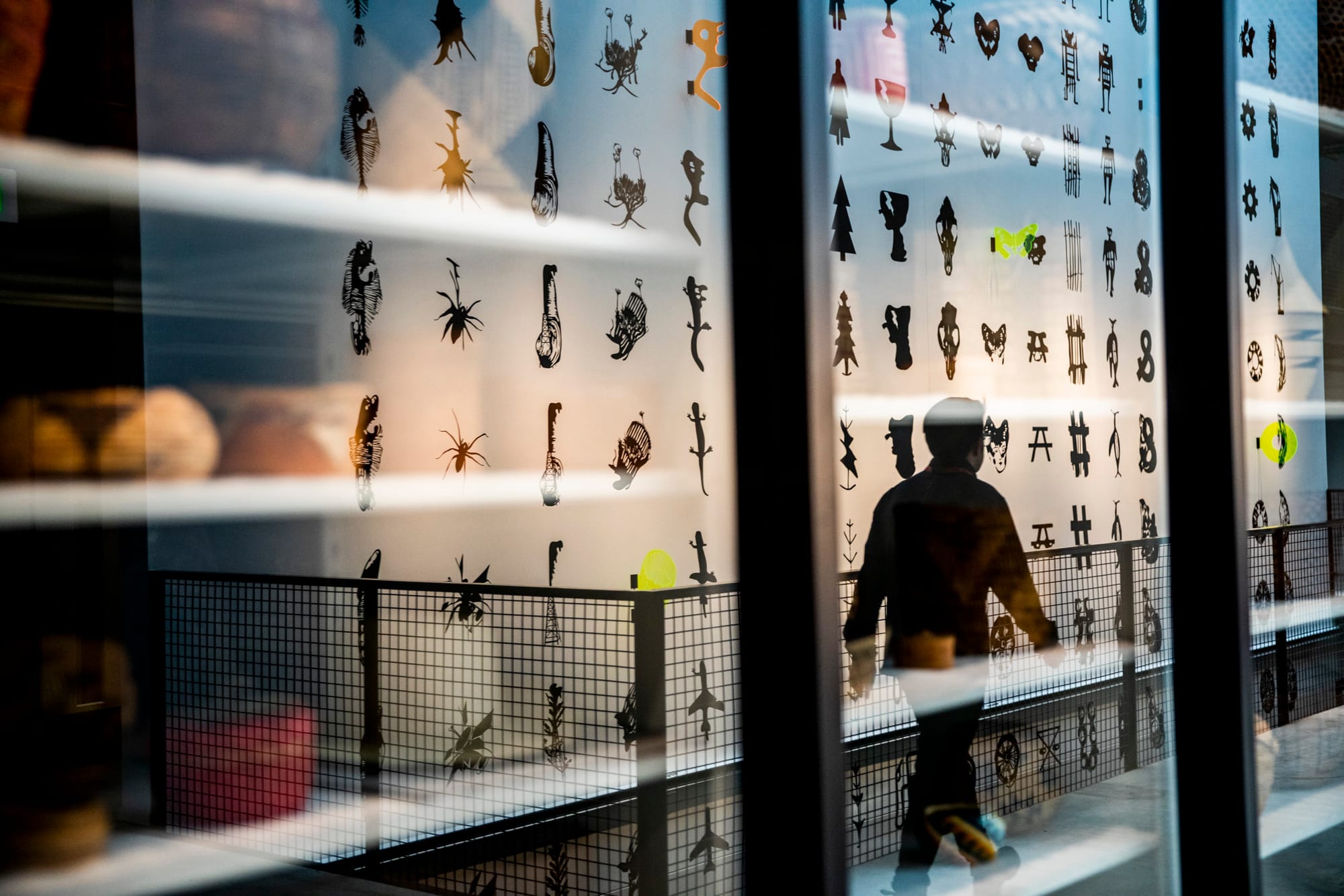 A mural of natural icons by RYAN! Feddersen seen through a window