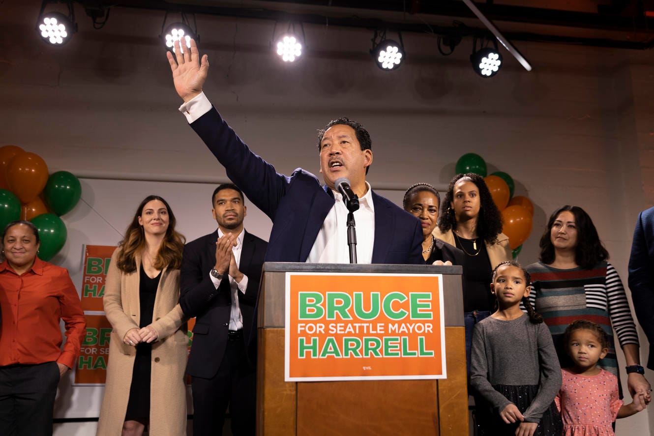 Seattle mayor-elect Bruce Harrell waves his hand from a stage
