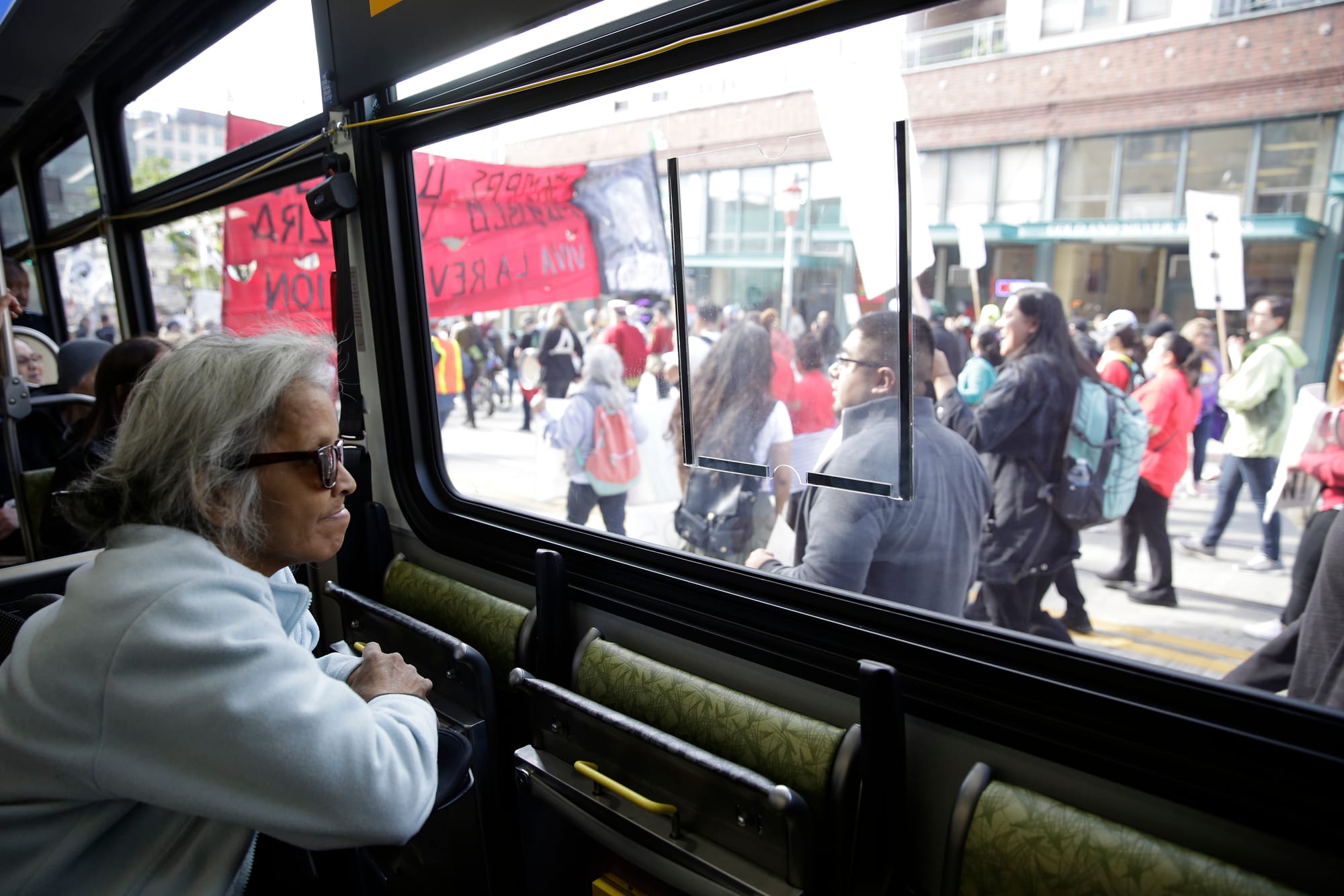 Darlene Hadley of Seattle watches from a bus stuck in traffic on South Jackson Street in the International District during the annual May Day March for Workers and Immigrant Rights in Seattle
