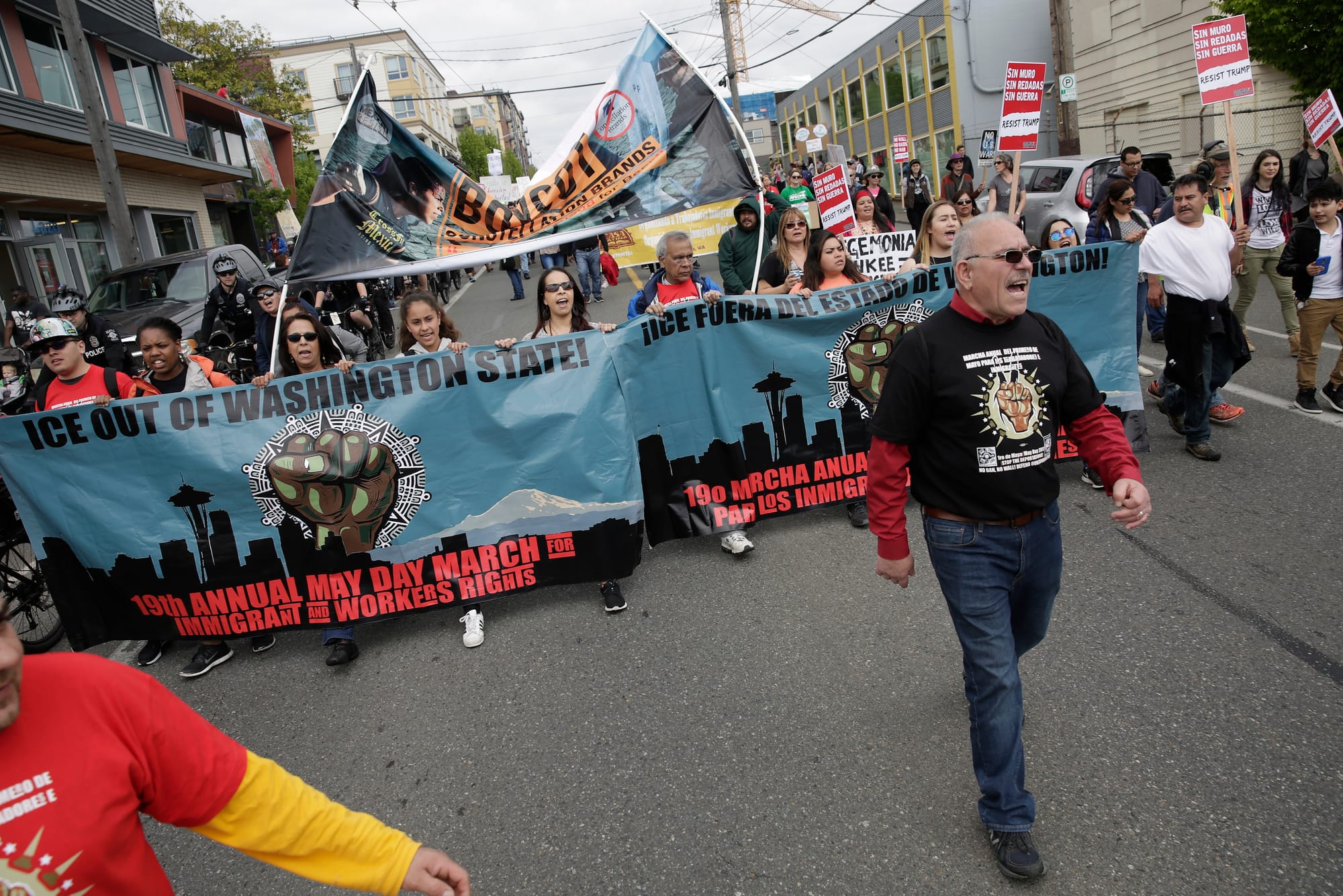 People carry banners as they march down South Jackson Street during the annual May Day March for Workers and Immigrant Rights in Seattle