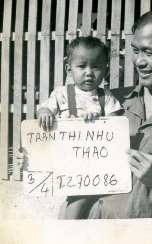 A dad holding a baby, holding a sign