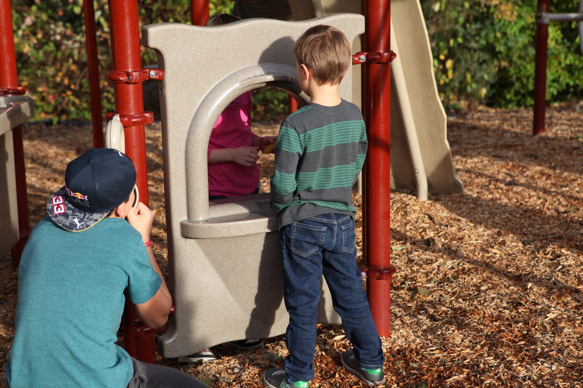Three children playing at a jungle gym