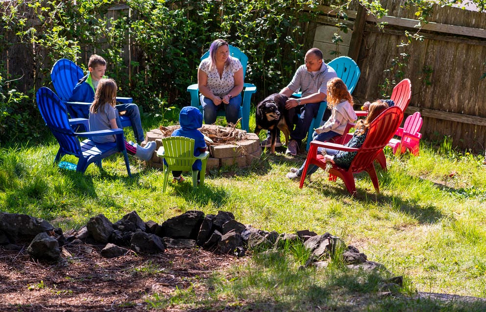 The family sits in their sunny backyard