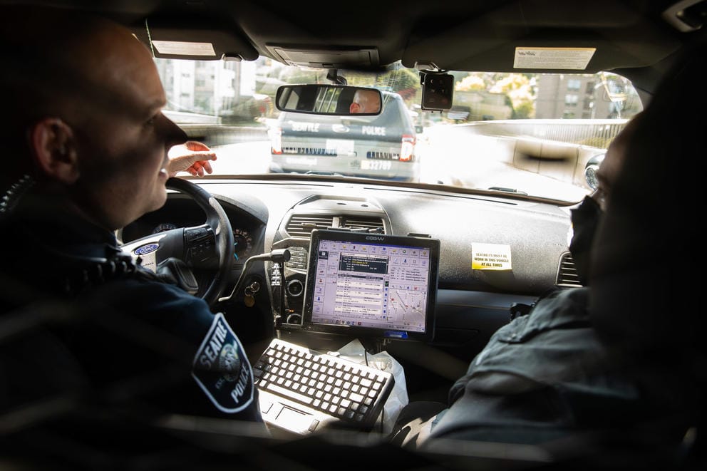 police in car driving to a scene