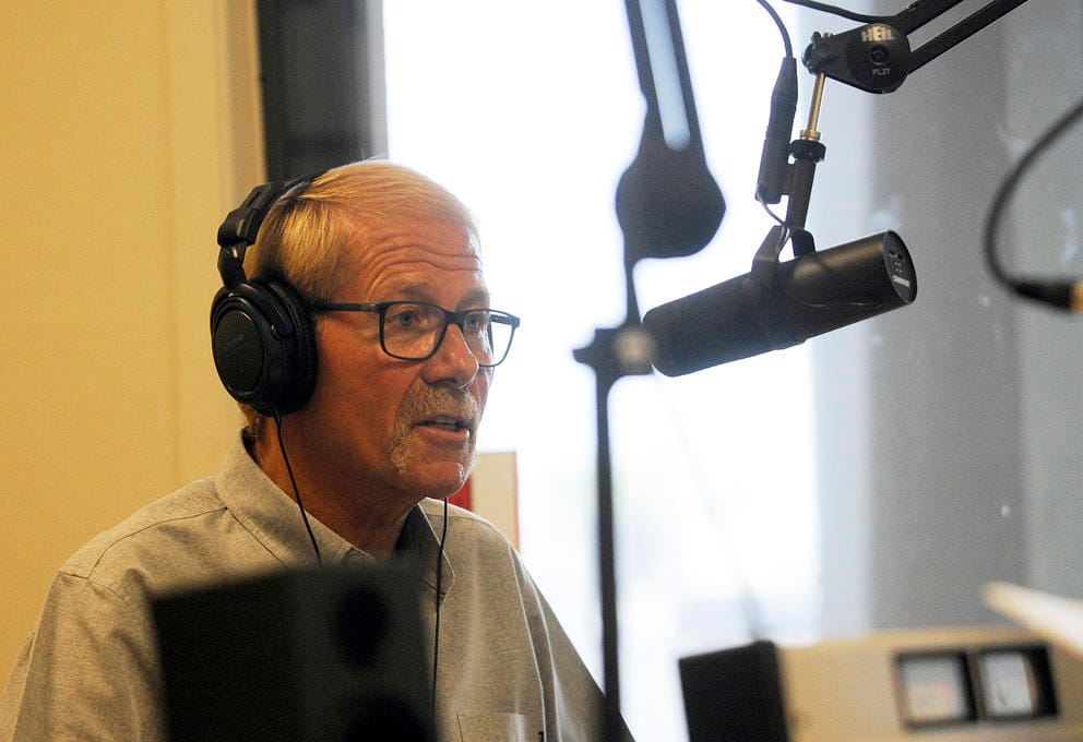 William Armacost in headphones in front of a microphone