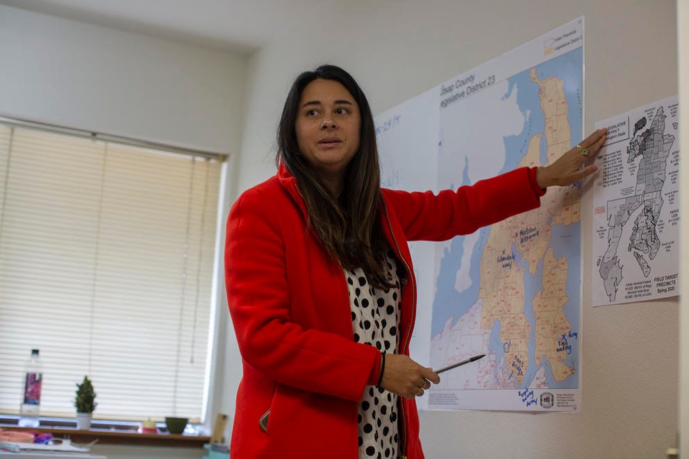 Erin Phillips points at a map of precincts on a wall