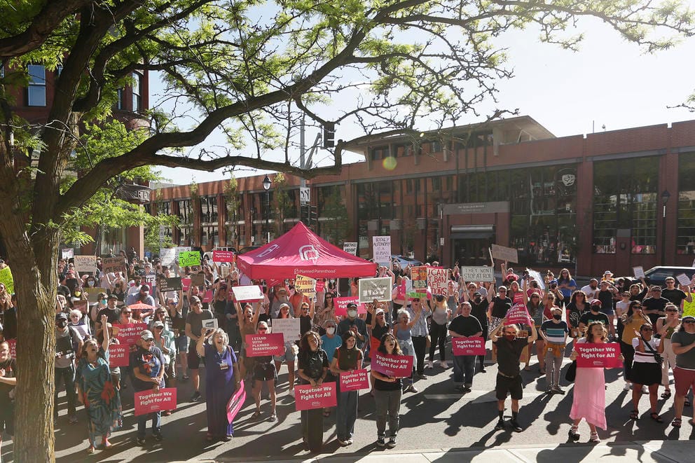 A crowd of pro-choice protesters hold signs reading