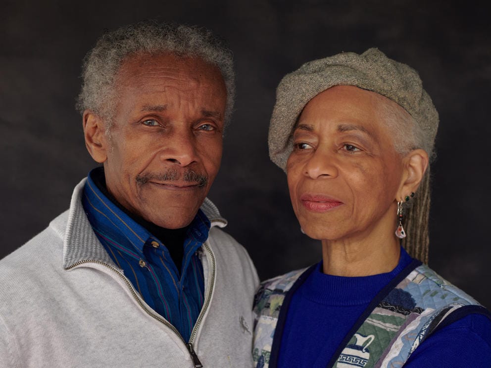 two people pose for the camera, they wear blue and white