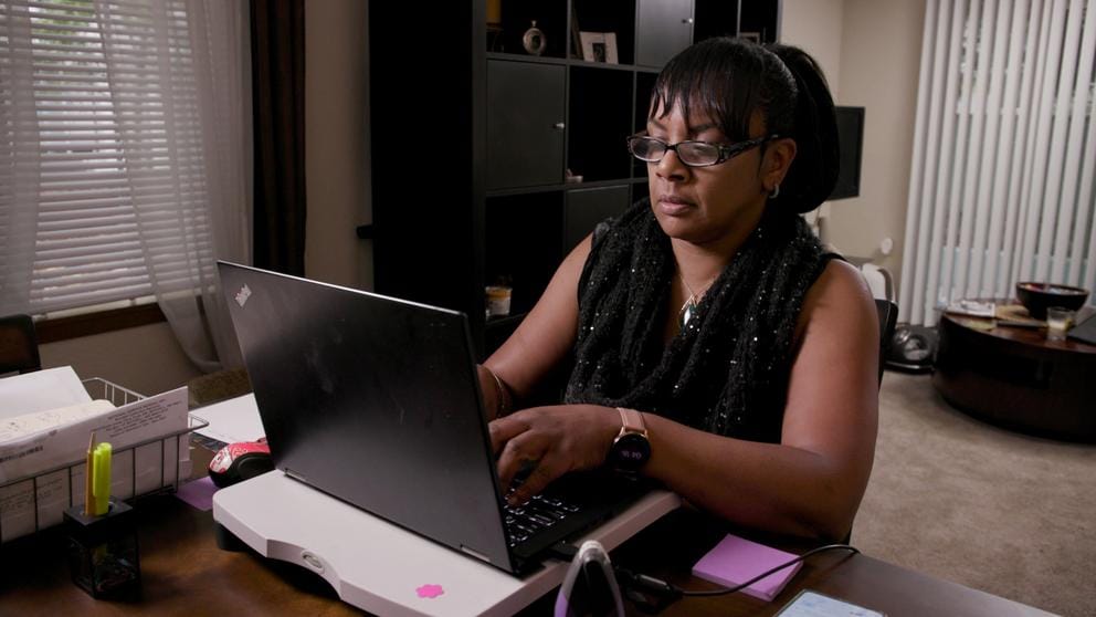 A woman types at a computer