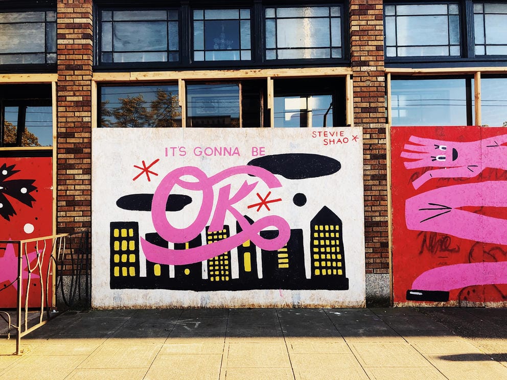 Mural with black downtown image and pink lettering stating: