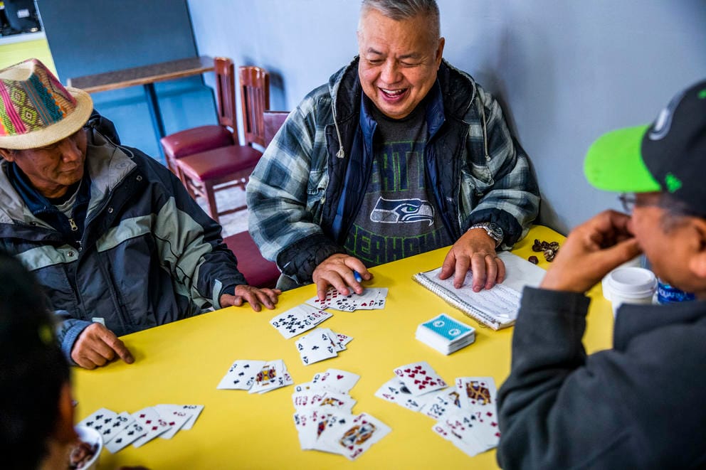 Ed Campos, 68, of Seattle plays a game of cards with other regulars at King Donuts in Rainier Beach on Wednesday, Nov. 14, 2018. Campos says he has been coming to King Donuts for the last 30 years.