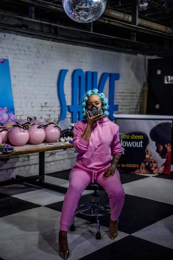 Person in pink outfit on stool, on checkerboard floor
