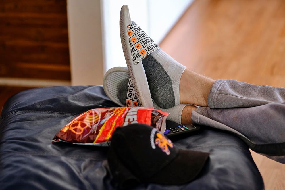 Teen at foster home rests his feet on an ottoman
