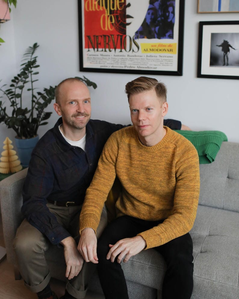 Ryan Hicks and Jeff Dorion pose for a photo on a couch in their home