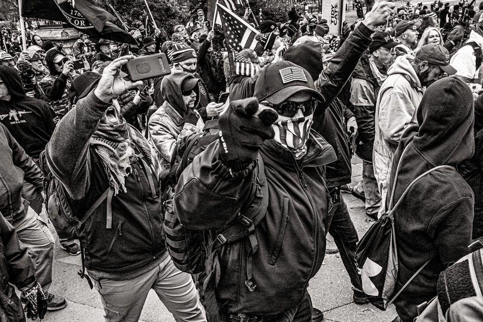 People march, one person points to the camera, photo in black and white