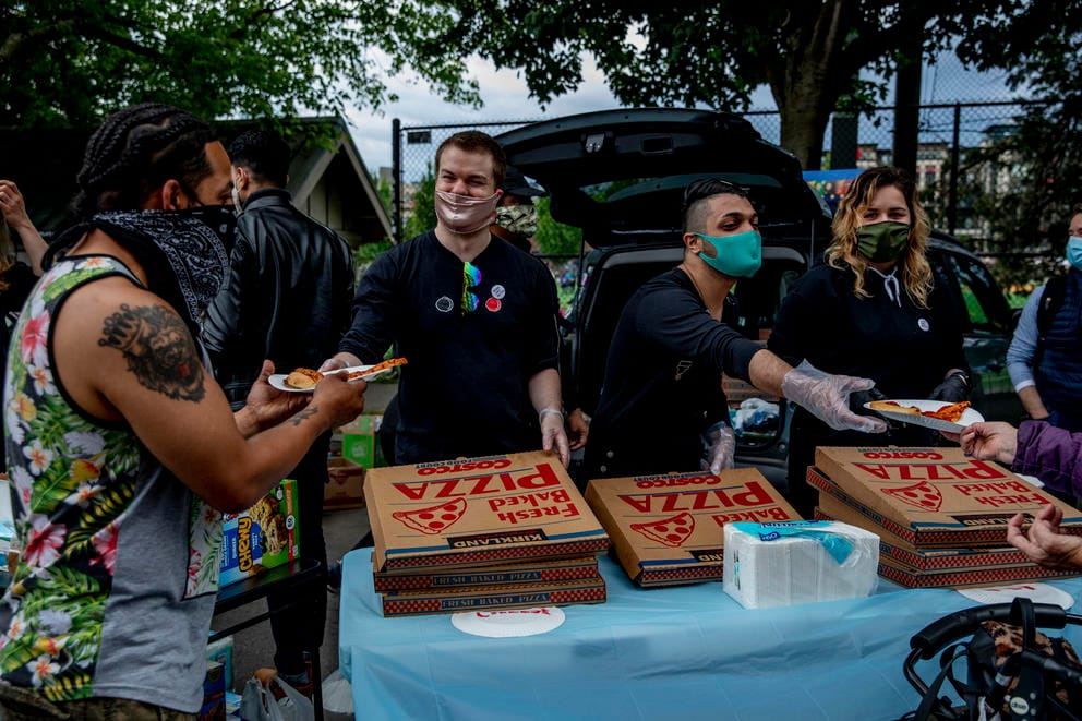 people handing out pizza