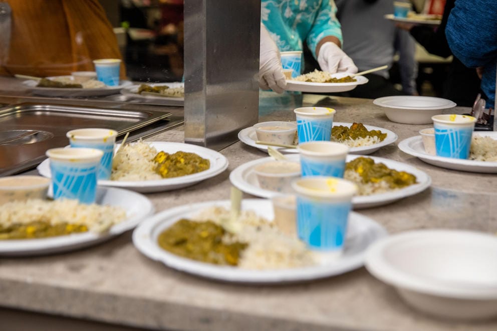 Dishes of traditional Indian food sit ready for serving on a table.