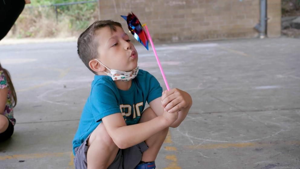 A child blows a pinwheel