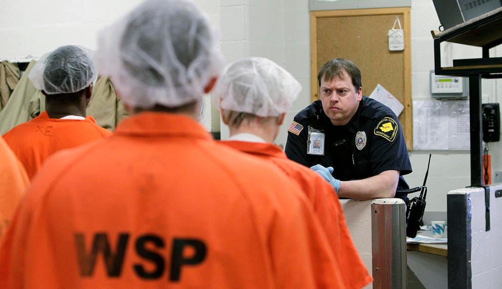 Officer watches prisoners working in Shelton