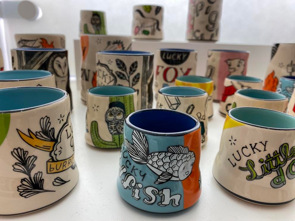 a photo of many small ceramic cups decorated with pictures of animals