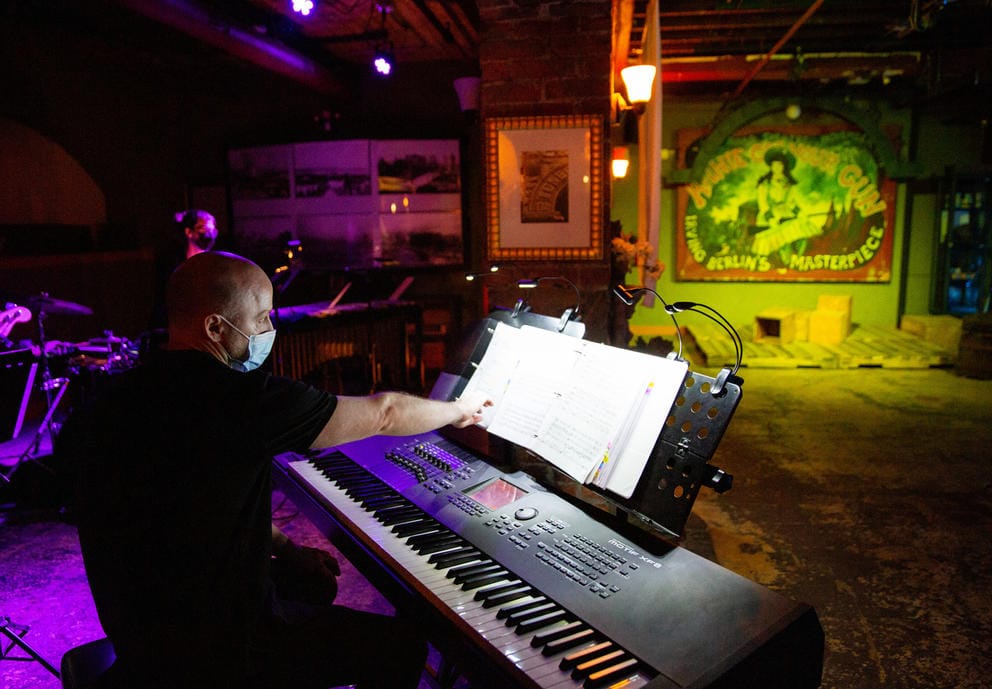A man sits behind a piano