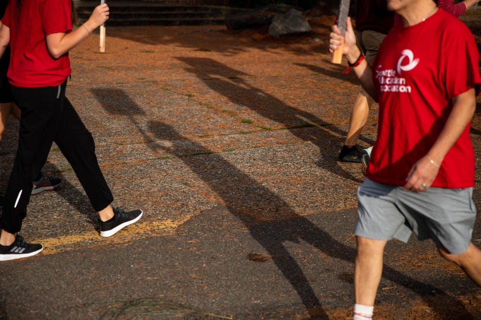 People with red shirts that read Seattle Education Association march while carrying signs.