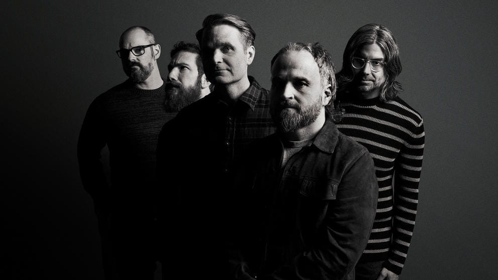 black and white photo of five white men posing for the camera