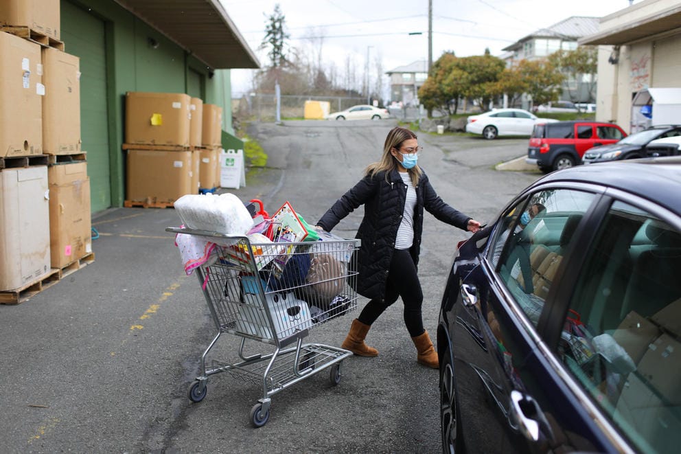 Karen Pool, who works for maternity support services for SeaMar Medical Clinic, loads a shopping cart full of toys, diapers and other baby supplies into her car at WestSide Baby.