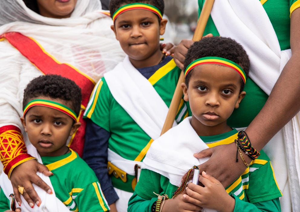 A close up of three boys wearing green and white