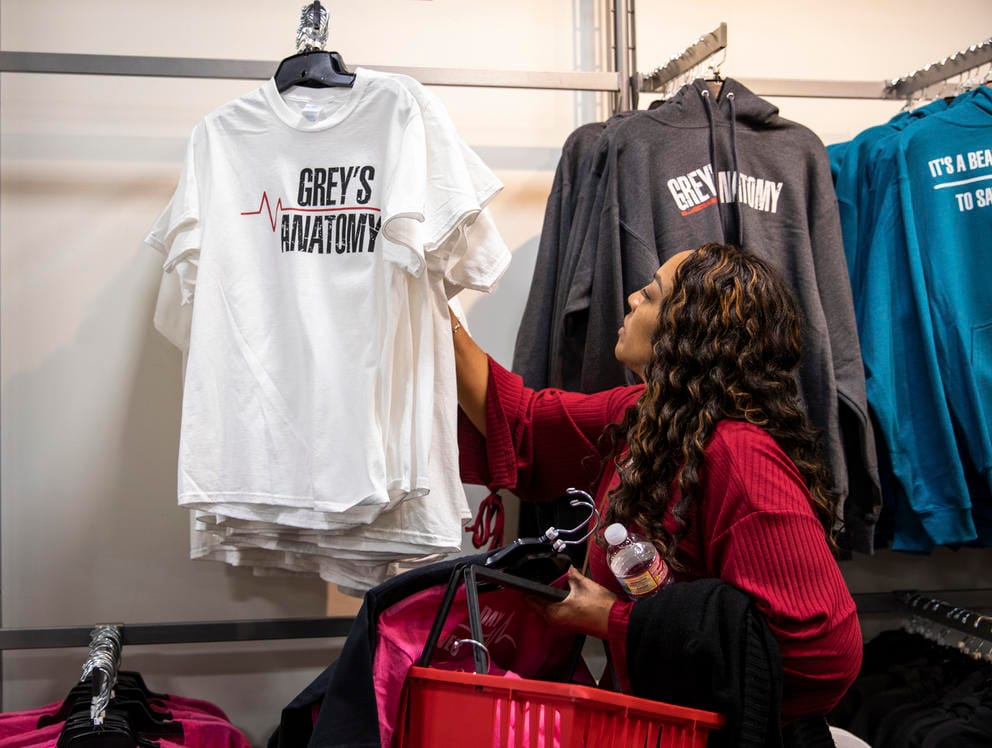 A woman browses through Grey's Anatomy novelty tshirts