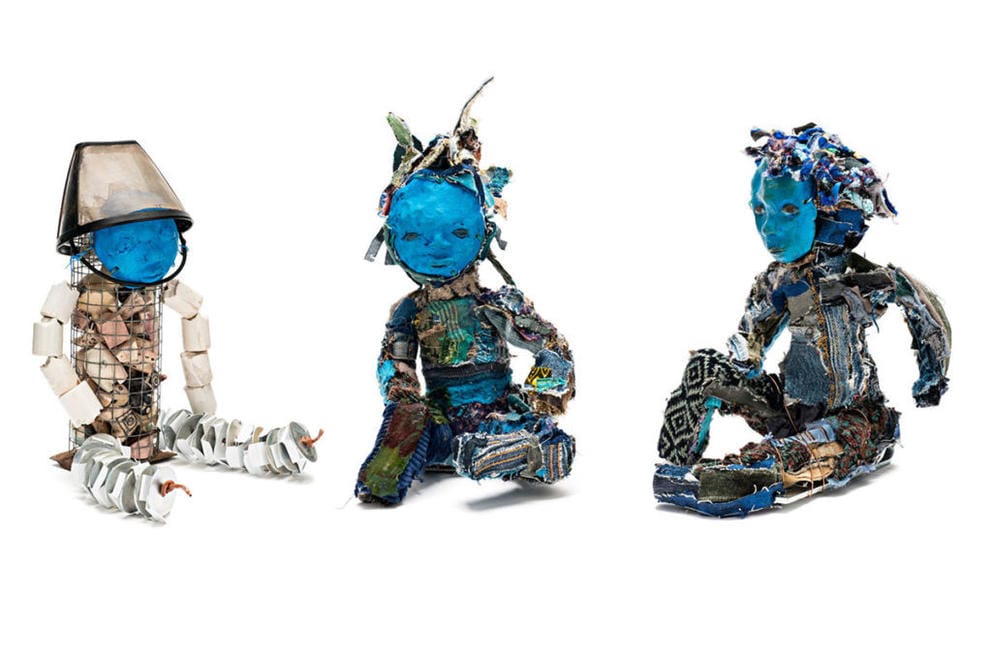 three sculptures of children with blue faces