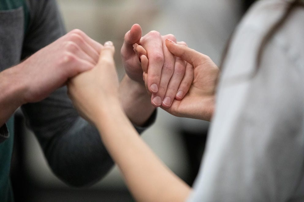 A close up of two people holding hands