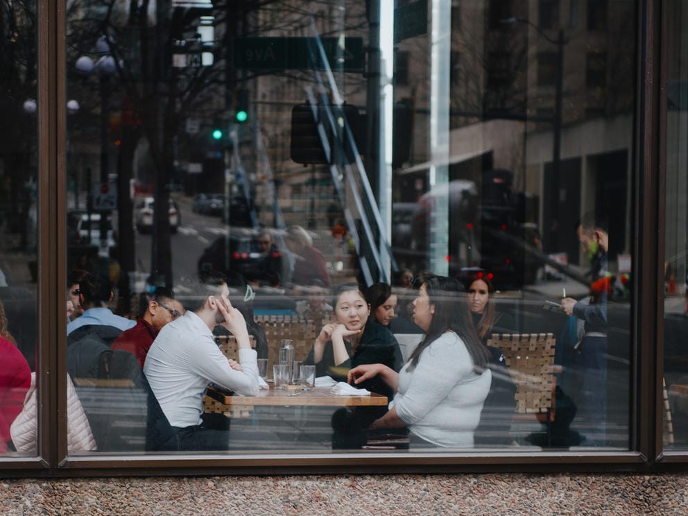 a group of diners sit at a table in a wine bar