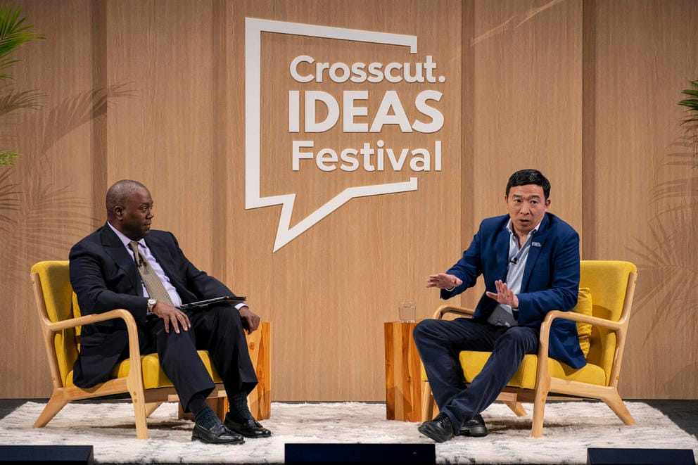 Two men seated on a stage