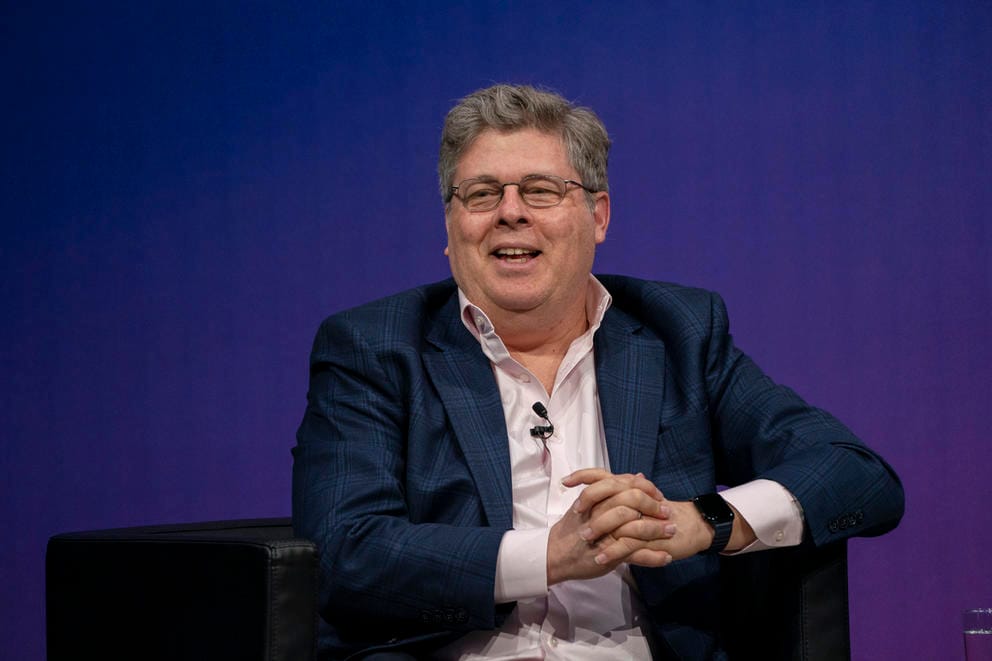 A man in a suitcoat, laughing