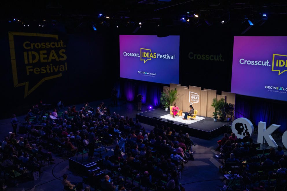 A long shot of the Crosscut Ideas Festival audience and lit-up stage