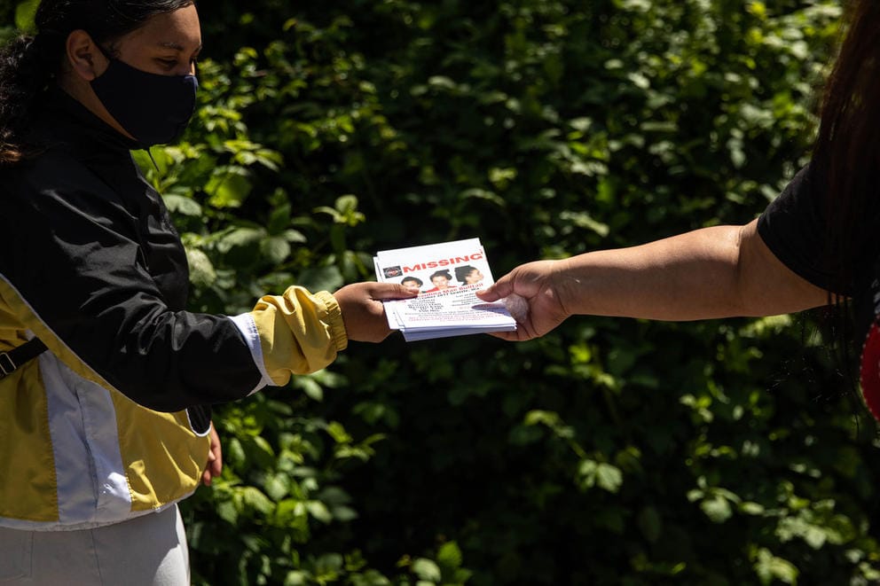 Roxanne White, right, hands out flyers