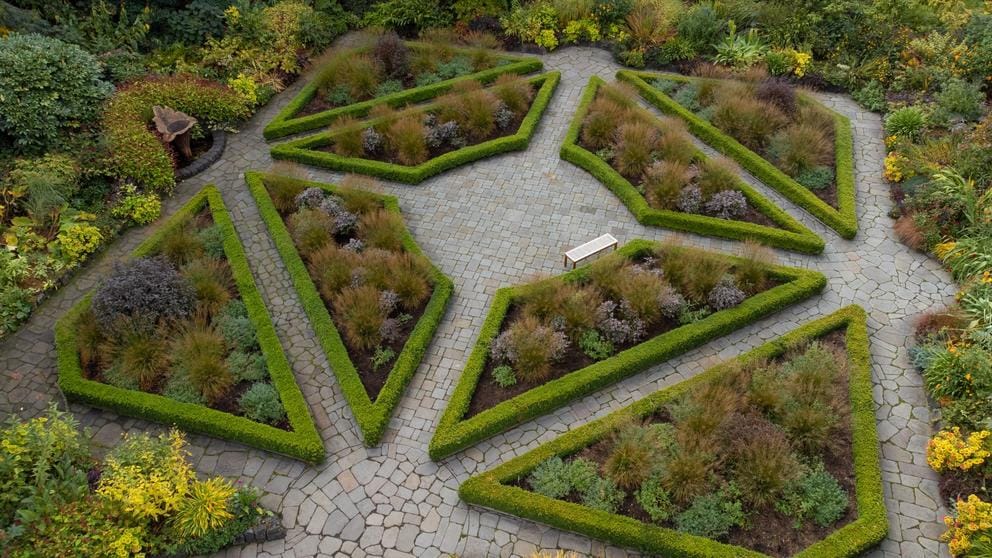 A square-like promenade with walkways through shrub gardens