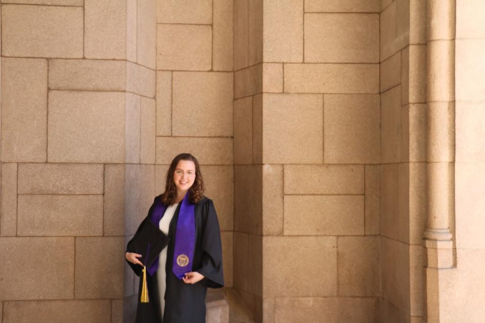 Julia Owens poses wearing her graduate regalia.