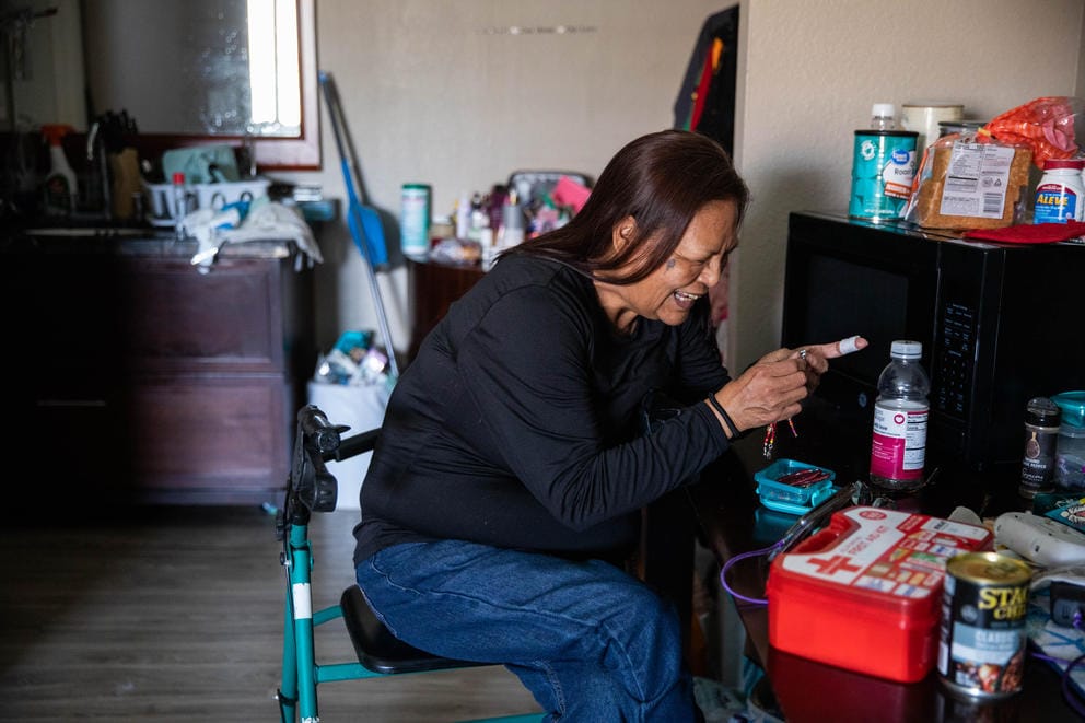 Jacqueline Gabriel goes through her beadwork in her apartmen