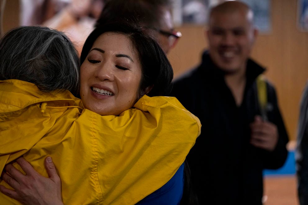 a woman hugs another person