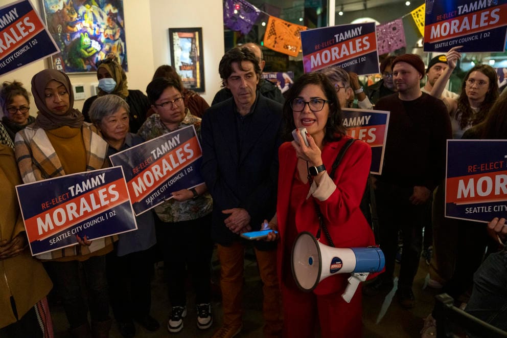 a woman speaks to a crowd on a megaphone
