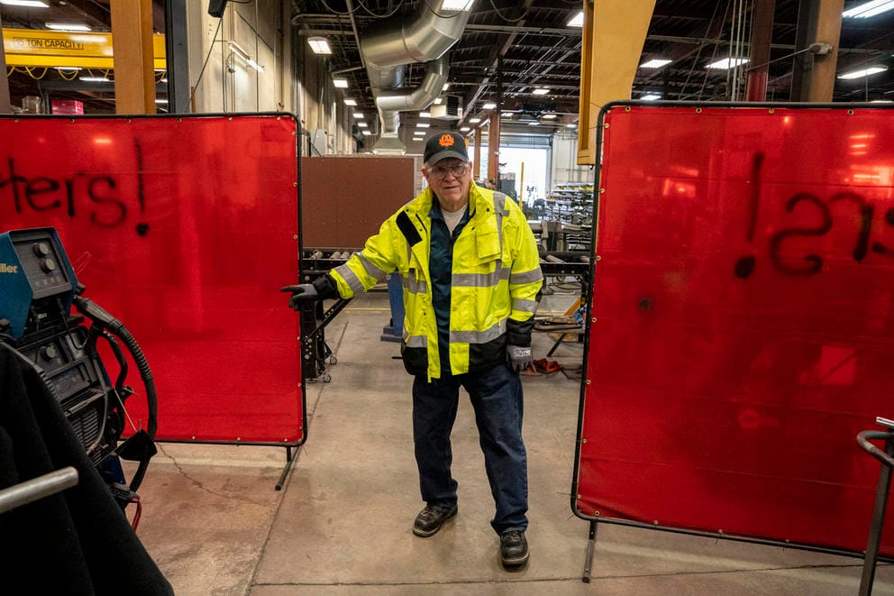 A man in a warehouse points.