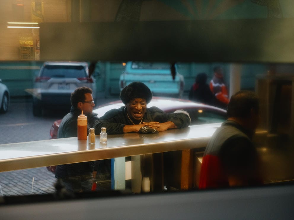 A man visits with employees as they close stalls at Mr. D’s Greek Delicacies