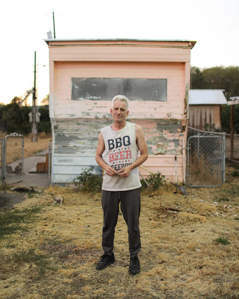 James Williams stands in front of his home in White Dove mobile home park, paint peels on the trailer