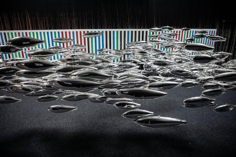 photo of a collection of suspended glass forms in the shape of fish